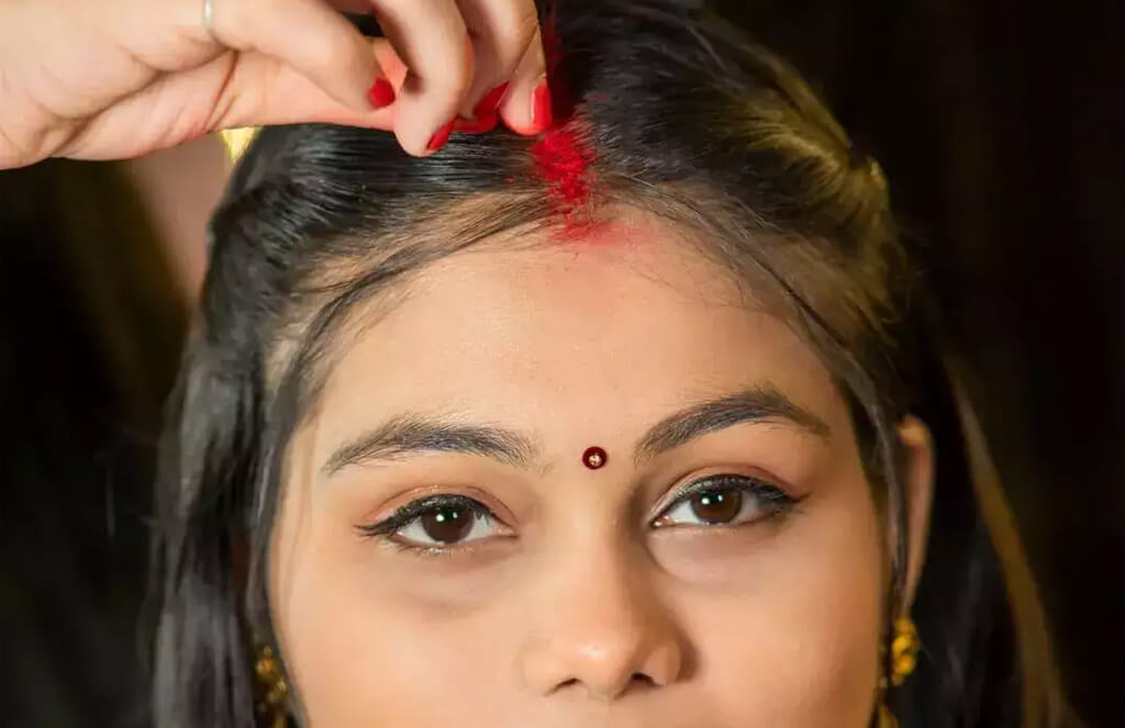 Woman applying sindoor